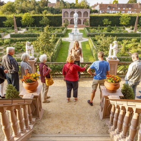 Photo of an English Heritage staff member speaking to a group of visitors in the Elizabethan garden at Kenilworth Castle