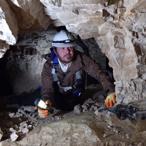 Photo of a person in a hard hat in the mines at Grime's Graves in Norfolk