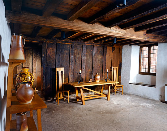 The parlour with low, heavy beamed ceiling and fine modern wooden furniture and pottery in traditional style The parlour with low, heavy beamed ceiling and fine modern wooden furniture and pottery in traditional style