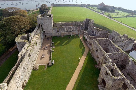 View of the outer bailey of Portchester Castle from the great tower, boats in the estuary beyond