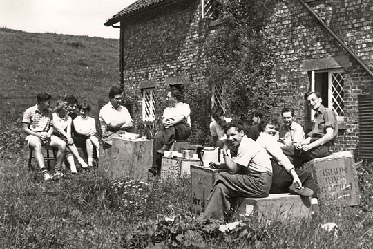 The historian Maurice Beresford, the archaeologist John Hurst, students, and the resident Milner family outside Wharram Percy Cottages in the 1950s
