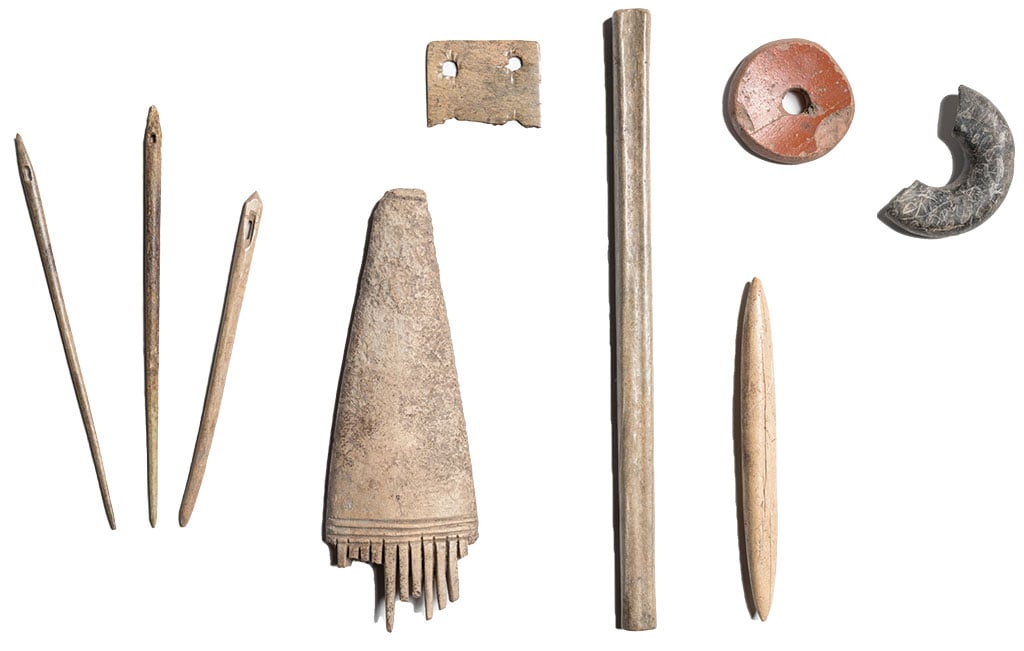 Looking from left to right shows three needles, a comb, part of a weaving tablet, a shuttle, a pin beater and two spindle whorls found at Wroxeter Roman City