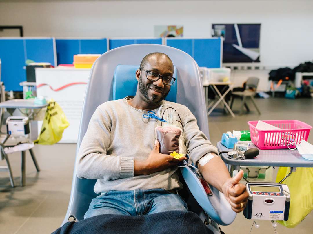 Image: a man is sitting down, donating blood to the NHS Image: a man is sitting down, donating blood to the NHS