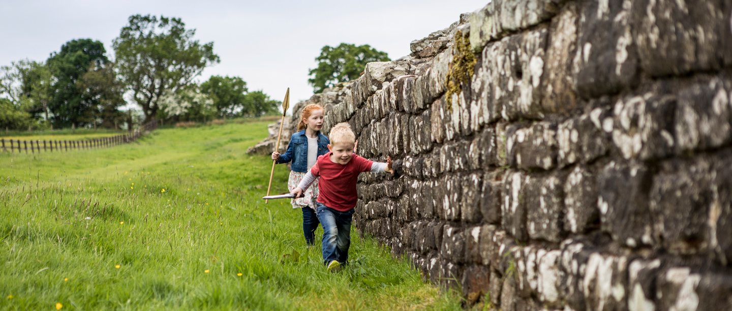 Two children run along Hadrian's wall