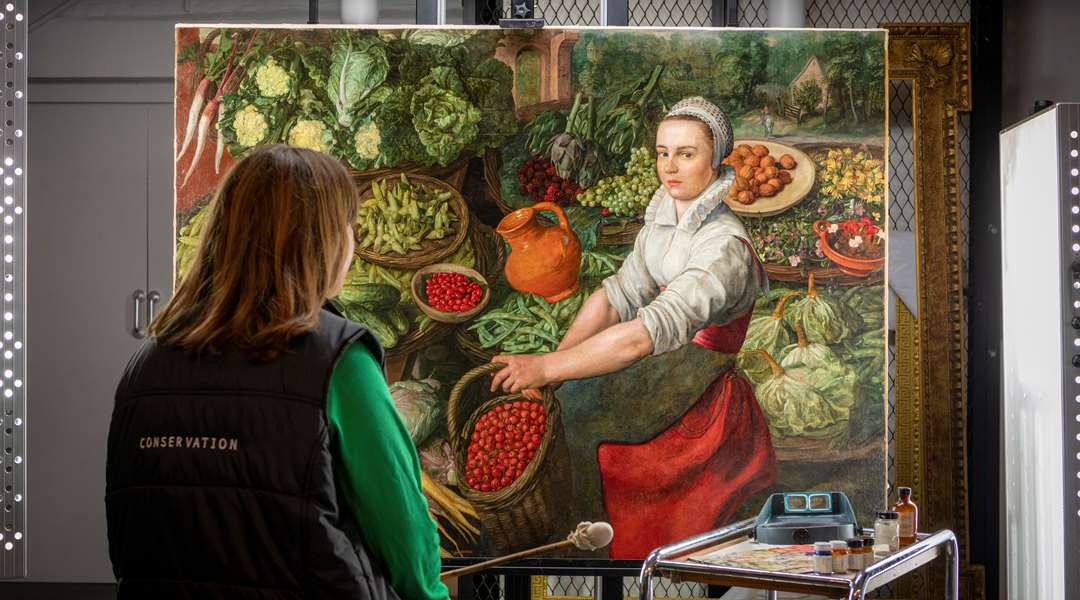 Image: a conservator looks at The Vegetable Seller