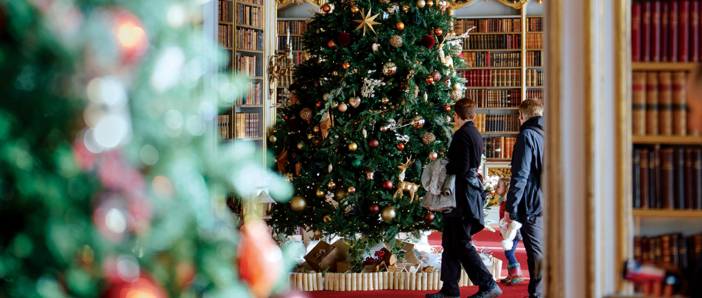 Two people look at a large decorated Christmas tree at Wrest Park.