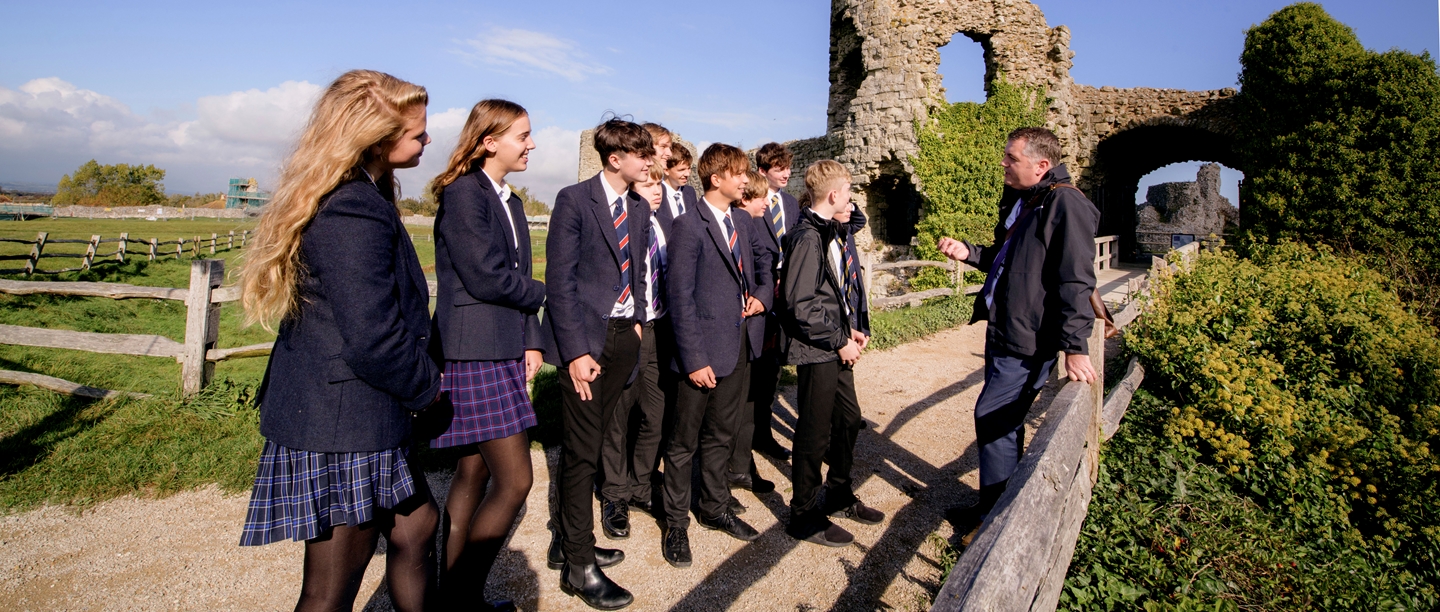 Image: Students learning from a teacher at Pevensey Castle
