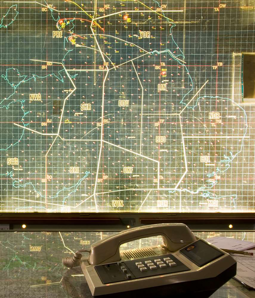 Colour photograph of a map of the UK divided into regions on which to plot nuclear strikes, with a telephone in the foreground