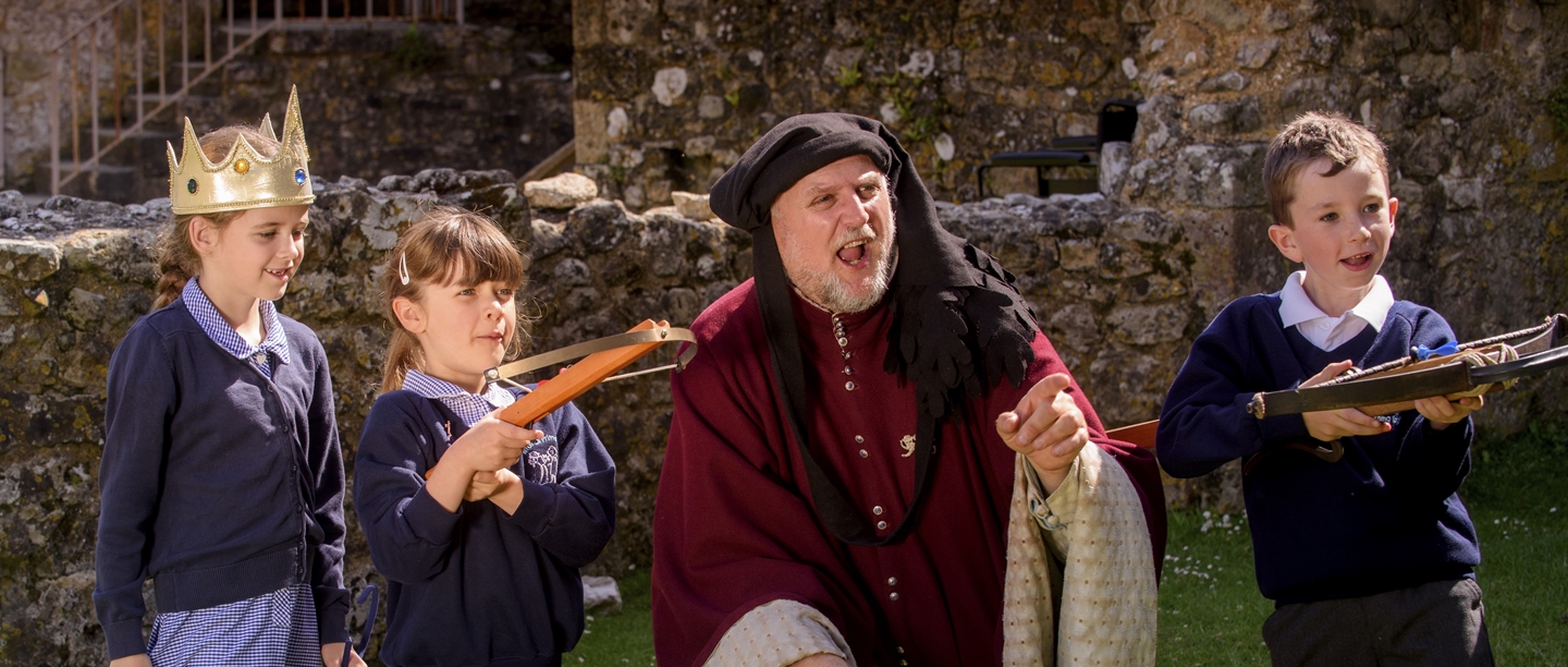 A man dressed as a medieval lord with a group of students