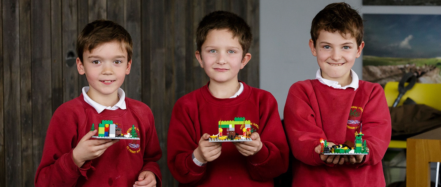 Three Primary School Students holding lego during a Discovery Visit to Stonehenge