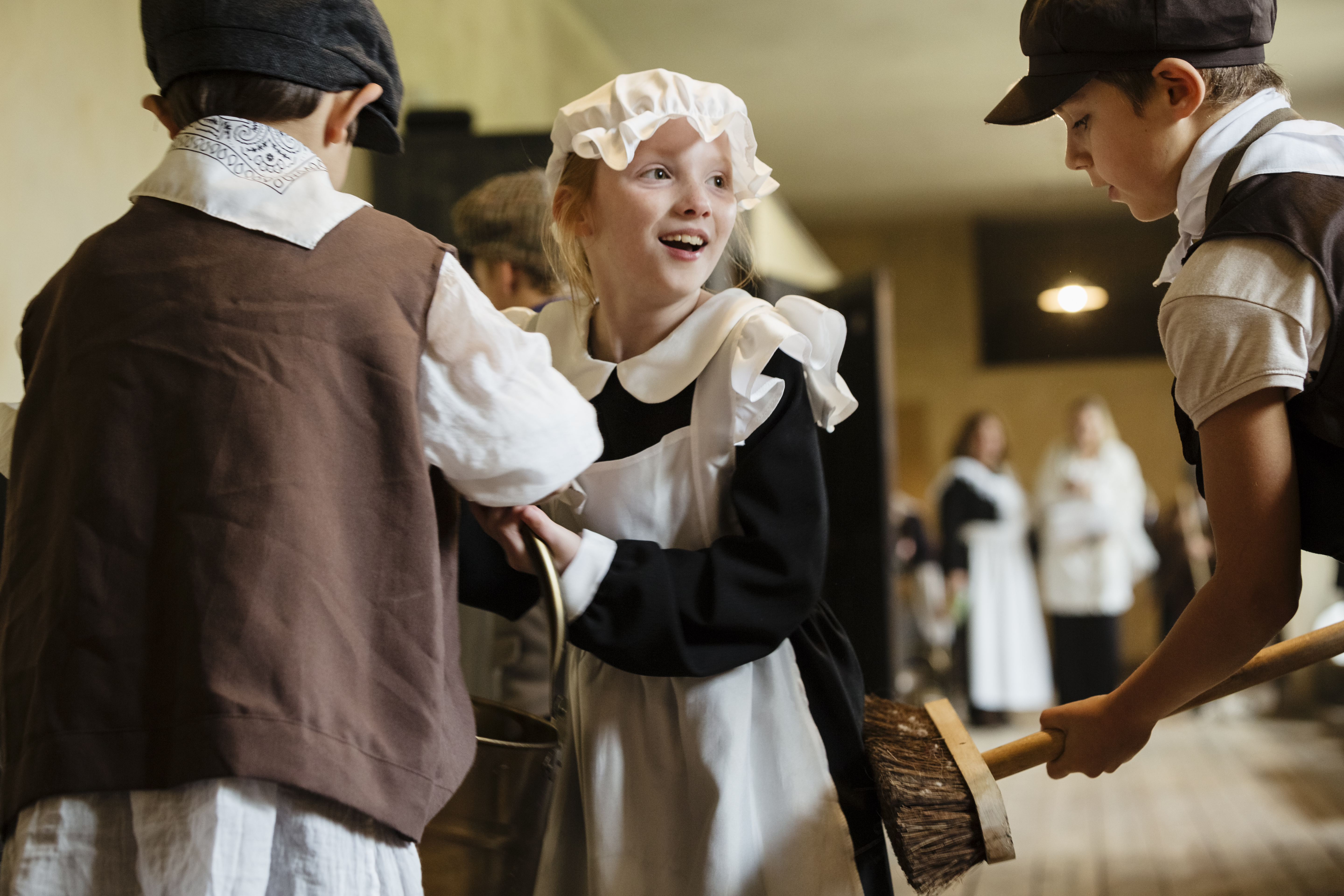 Boys and girls wearing Victorian servant costumes in the Coal Gallery at Audley End