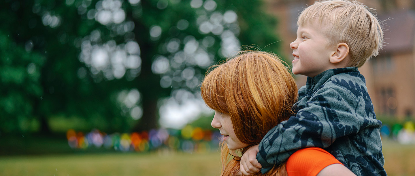 A young boy gets a piggy back from a girl