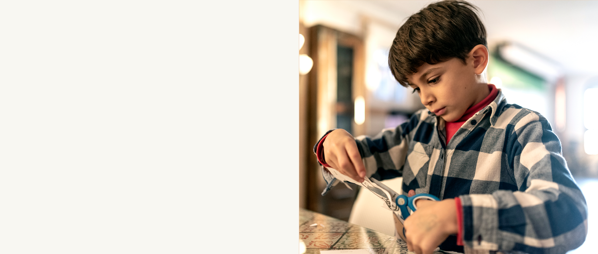 A young boy cuts paper with scissors