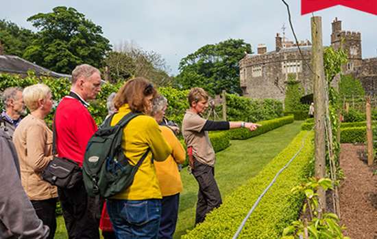 Image: visitors exploring gardens at Walmer Castle with a gardener