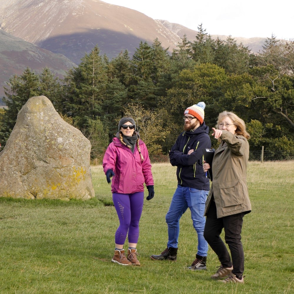 Photo of two visitors and an English Heritage volunteer at Castlerigg Stone Circle