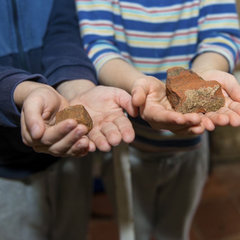 Photo of two children holding stone artefacts at North Leigh Roman Villa