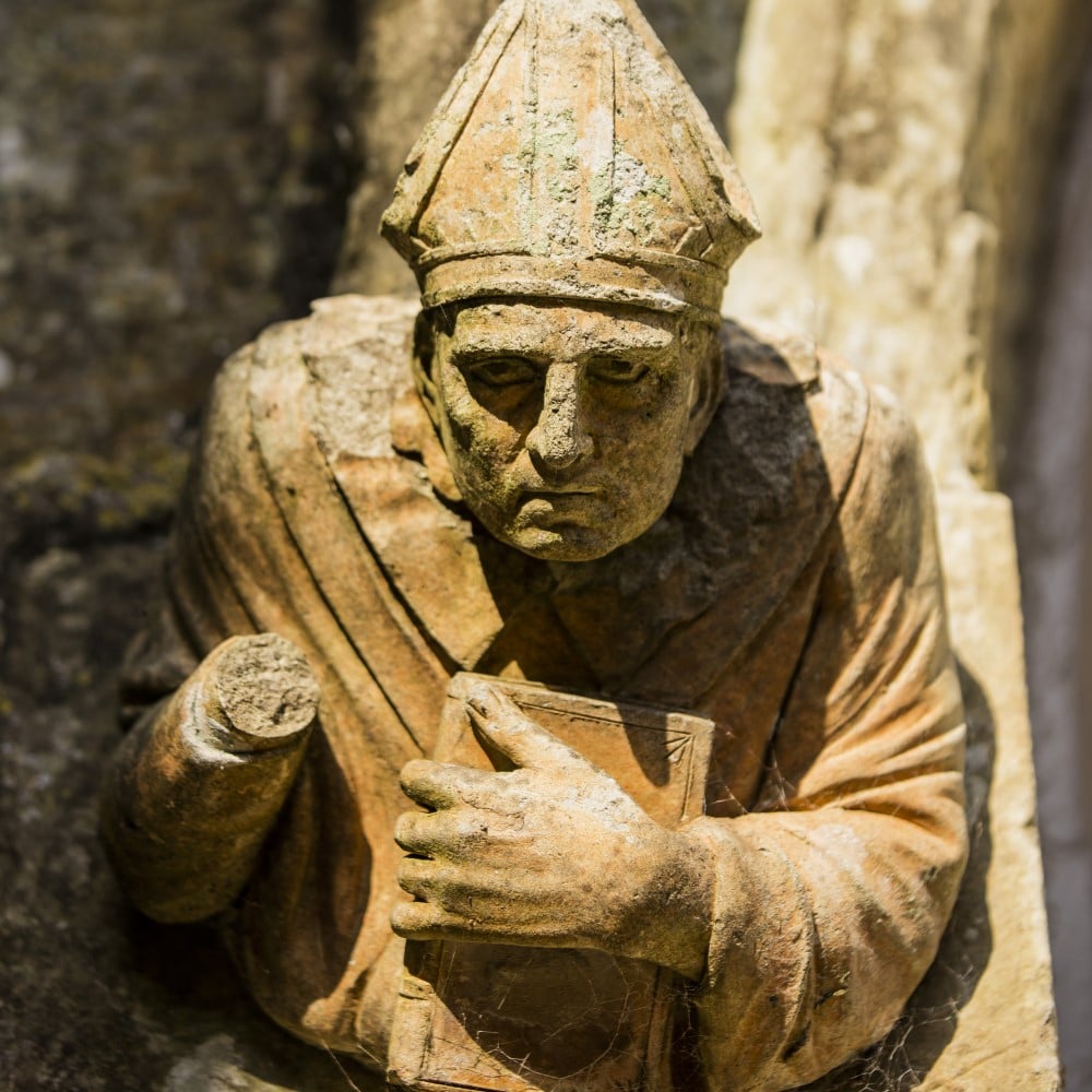 Photo of a stone carving of a priest at Battle Abbey