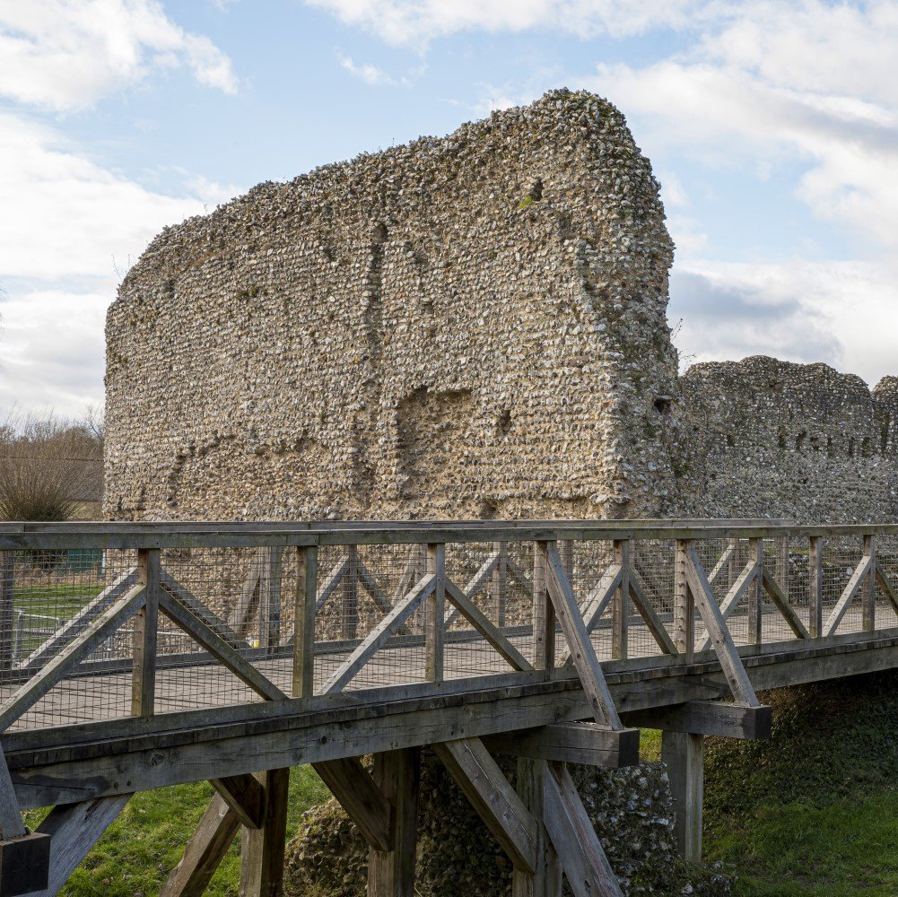 Photo of the remains of Eynsford Castle with a footbridge in the foreground