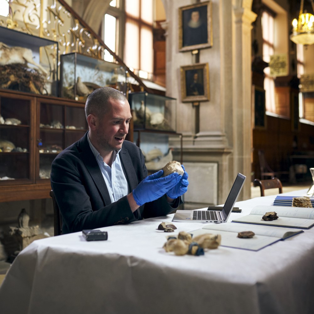 Photo of curator Dr Peter Moore examining an artefact at Audley End House and Gardens