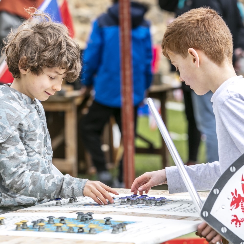 Photo of two children playing a medieval board game