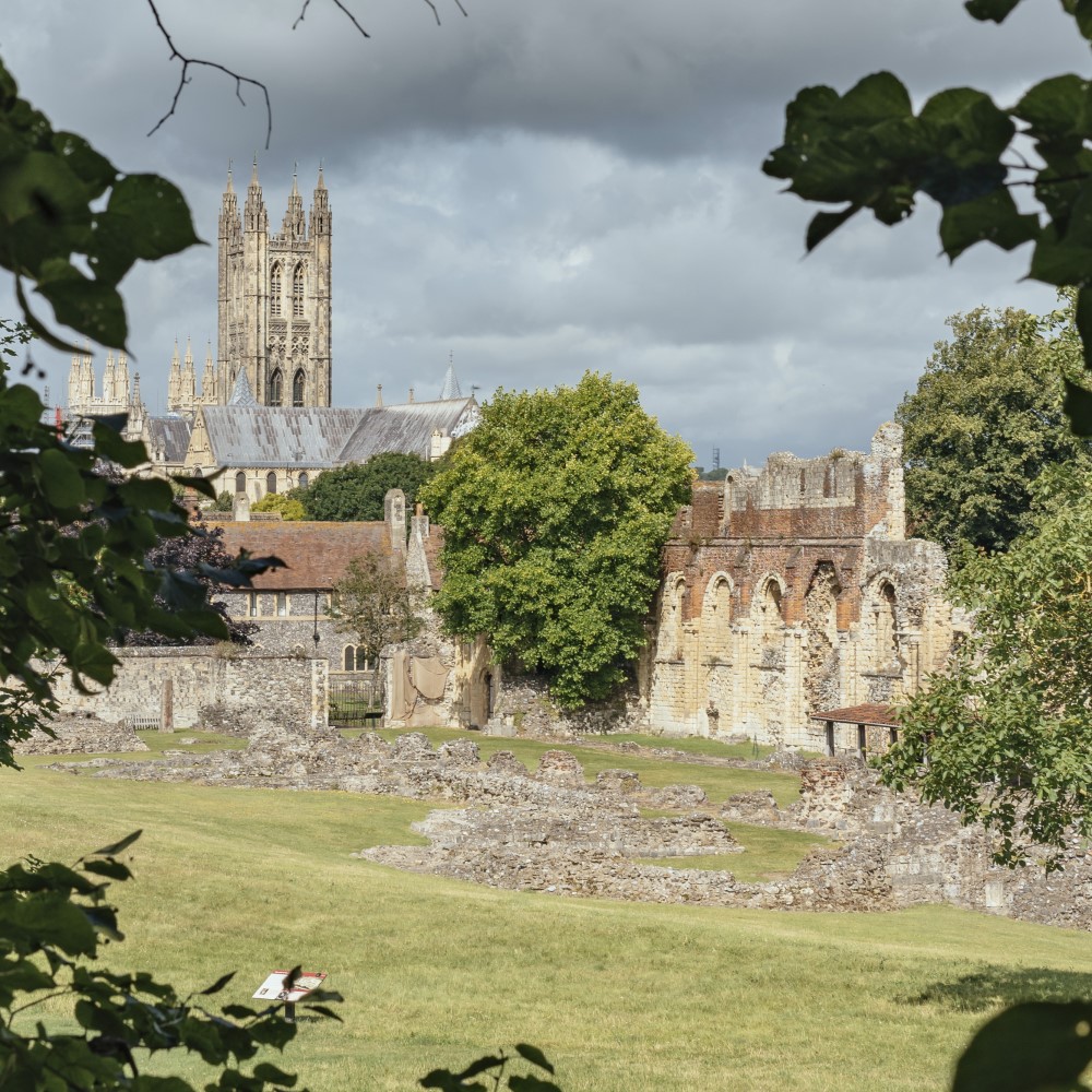 Photo of the remains of St Augustine's Abbey with the tower of Canterbury Cathedral in the distance