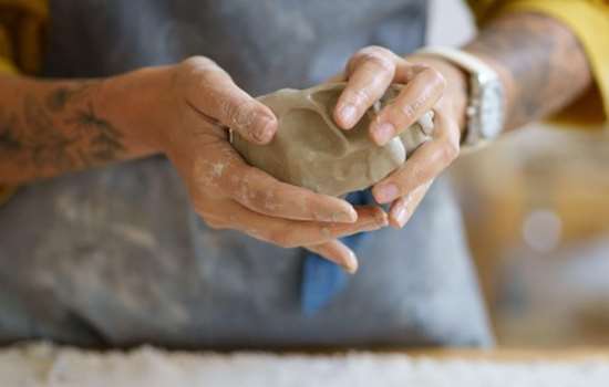 Photo of a person moulding a lump of clay with their hands