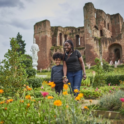 Photo of an adult and child looking at wildflowers in the Elizabethan Garden at Kenilworth Castle