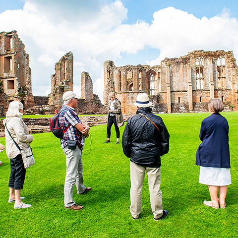 Image: tour guide with visitors at Kenilworth Castle