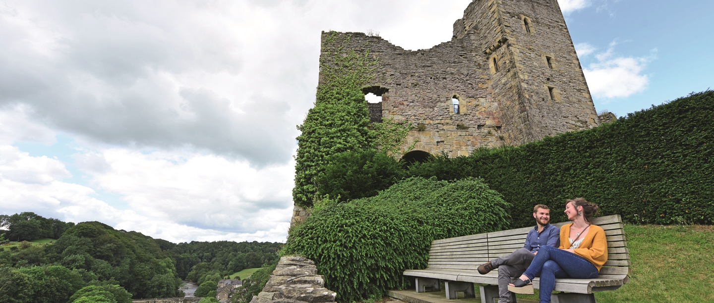 Image: Visitors sit outside a castle