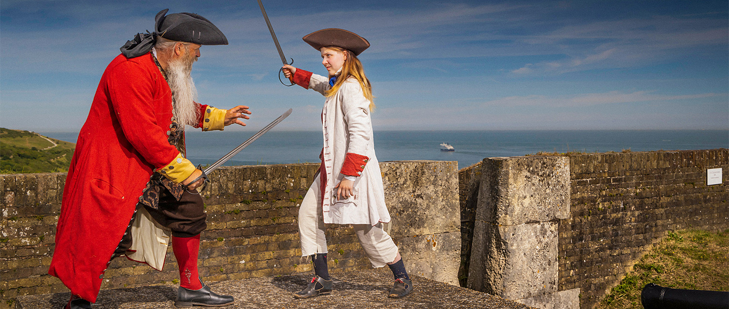 Two pirate re-enactors sword fighting