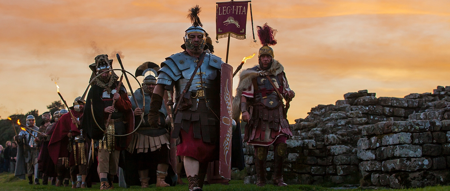Image: Roman re-enactors marching by Hadrian's Wall at sunset