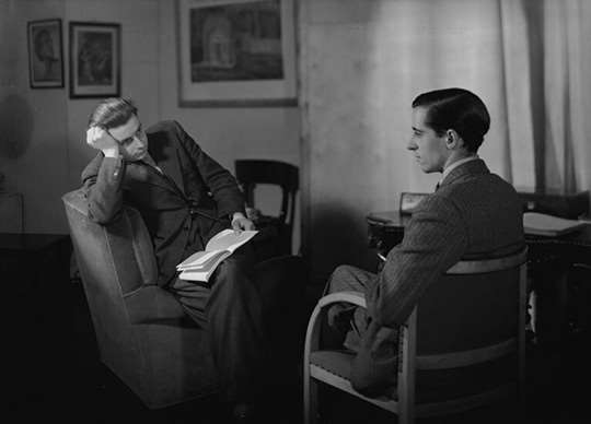 A black and white image of Mass-Observation founders Tom Harrisson and Charles Madge sitting opposite each other A black and white image of Mass-Observation founders Tom Harrisson and Charles Madge sitting opposite each other