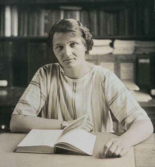 Monochrome photograph of Cecilia Payne-Gaposchkin sitting in the Maria Mitchell Observatory with glass plates behind her