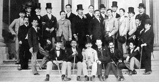 Black and white portrait photograph of a group of Filipino scholars and independence campaigners. The photograph is from 1890 and the young men all wear Victorian suits; some wear top hats and others bowlers, and many carry canes Black and white portrait photograph of a group of Filipino scholars and independence campaigners. The photograph is from 1890 and the young men all wear Victorian suits; some wear top hats and others bowlers, and many carry canes