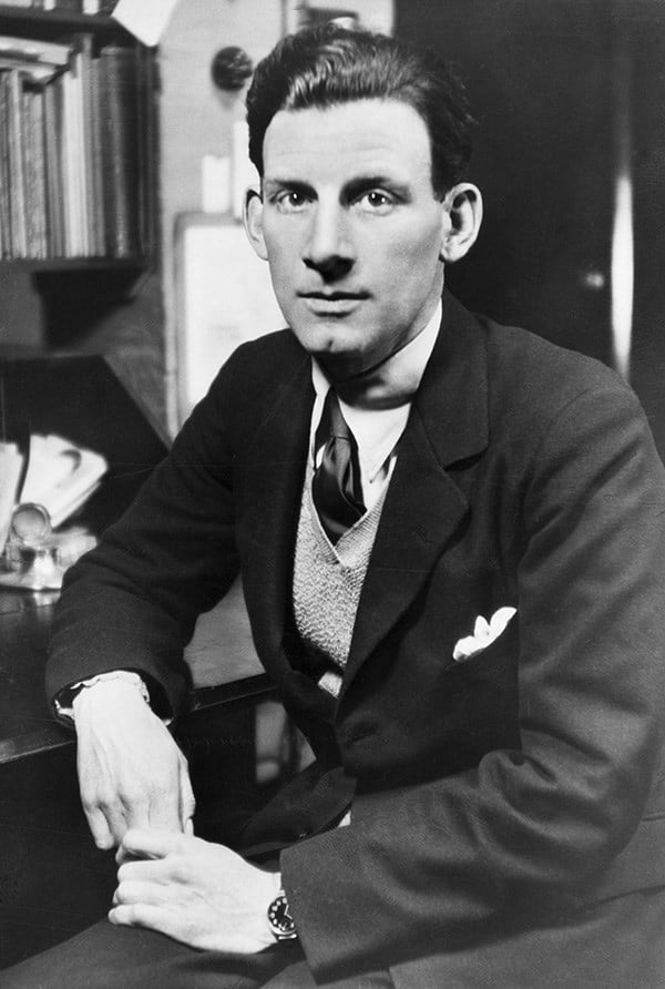 Black and white photograph of the war poet Siegfried Sassoon, seated at desk