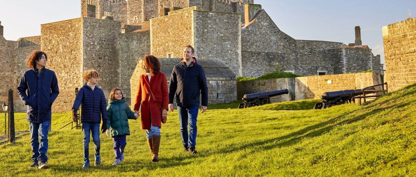 Photo of two adults and three children walking in the grounds of Dover Castle in the winter