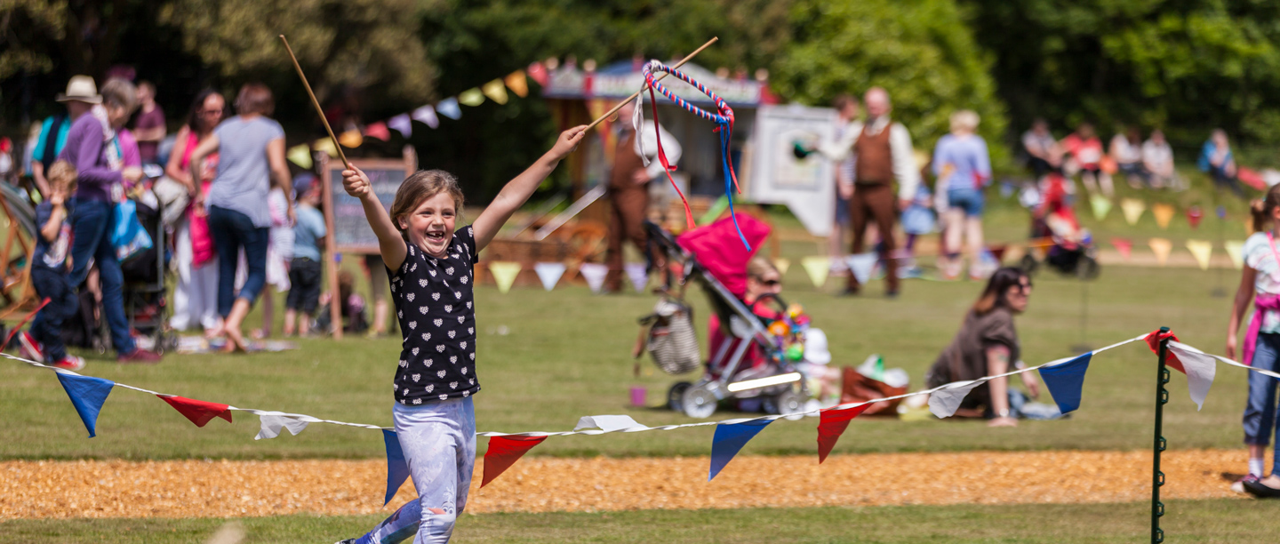 A young girl raises her hands while practicing some circus related activities on the lawn at Osborne.