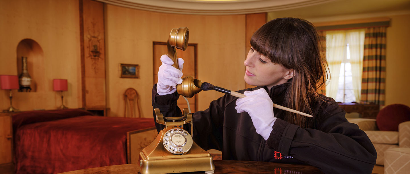 A conservator examines an historic telephone