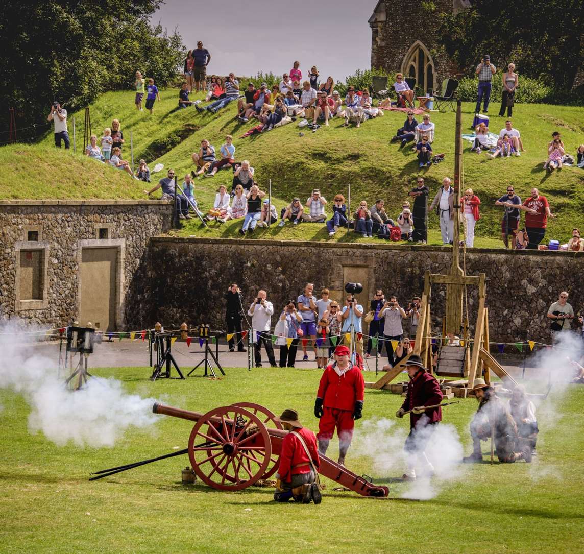 Image: People watch a cannon being fired at Dover Castle