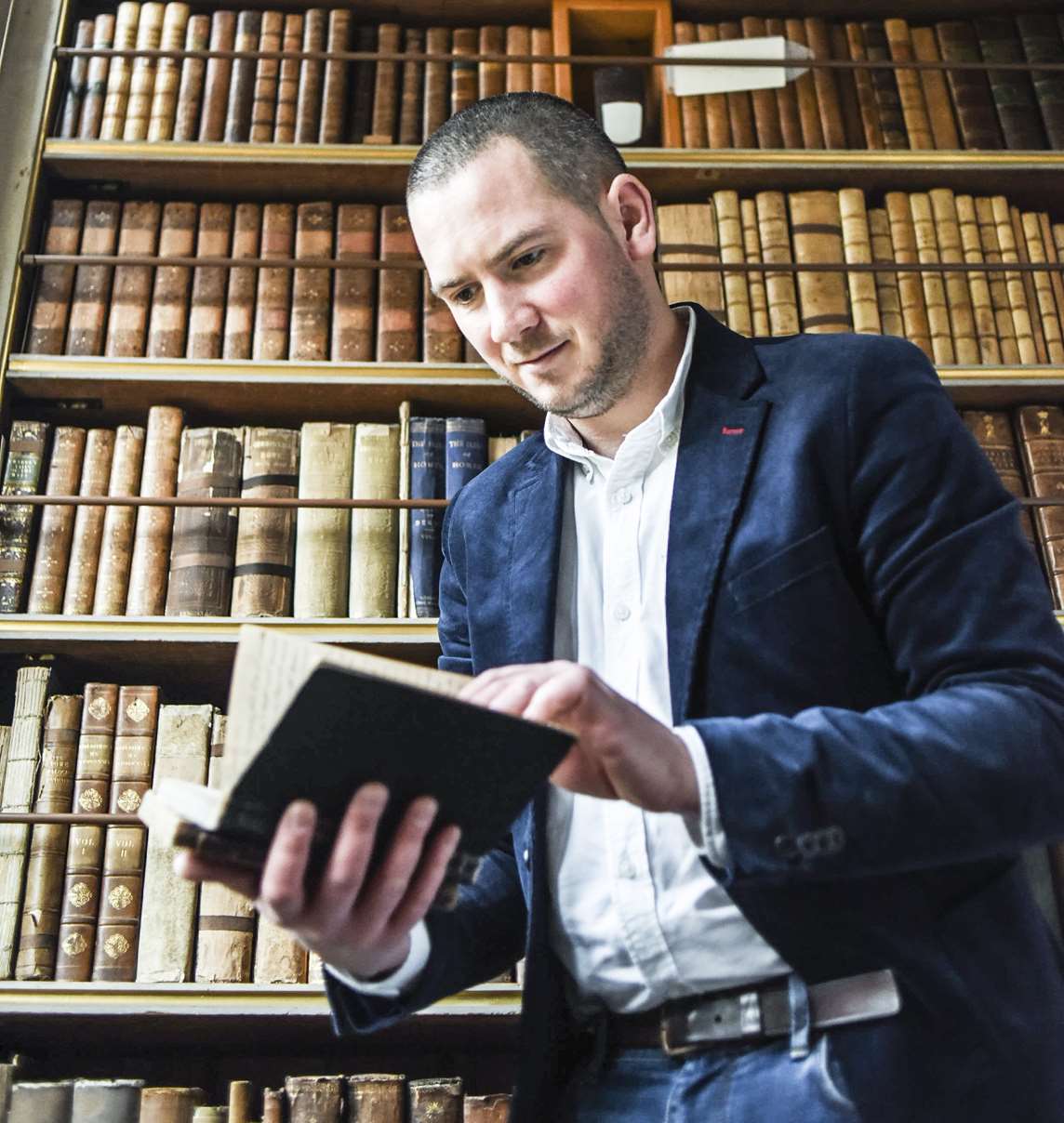 Image: A man reading a book in the library at Audley End House and Gardens Image: A man reading a book in the library at Audley End House and Gardens