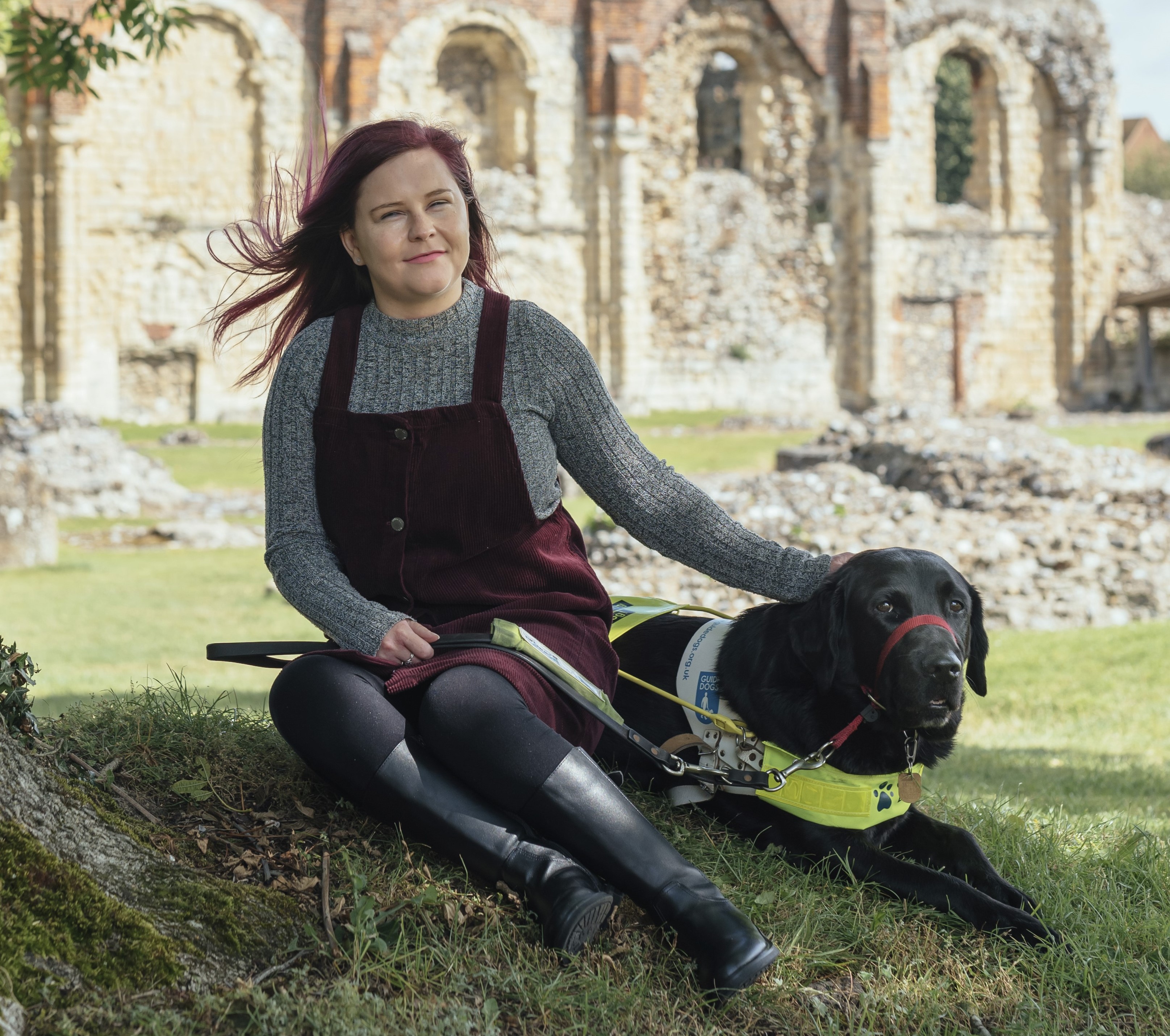 Image: A person and their guide dog sat in the shade