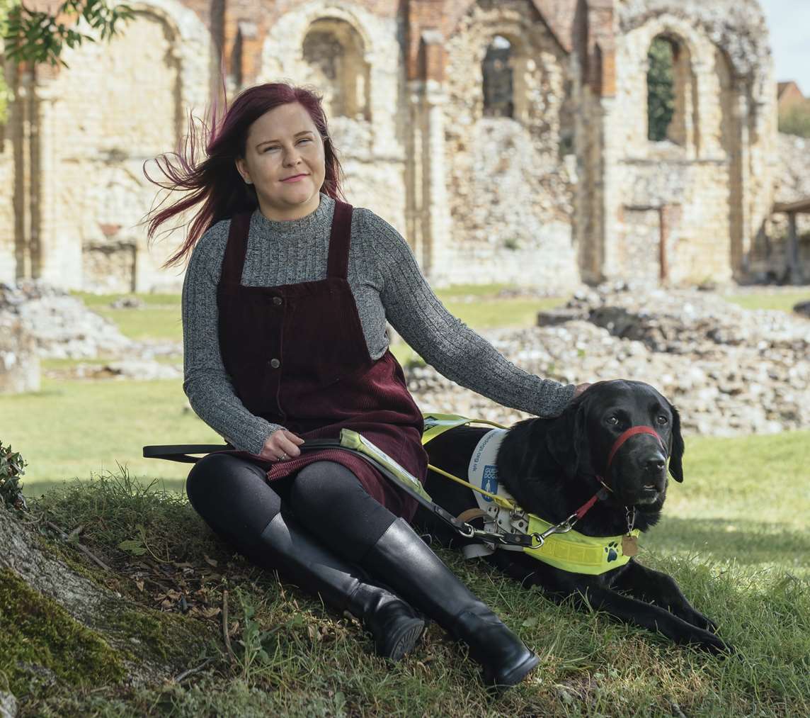 Image: A person and their guide dog sat in the shade Image: A person and their guide dog sat in the shade