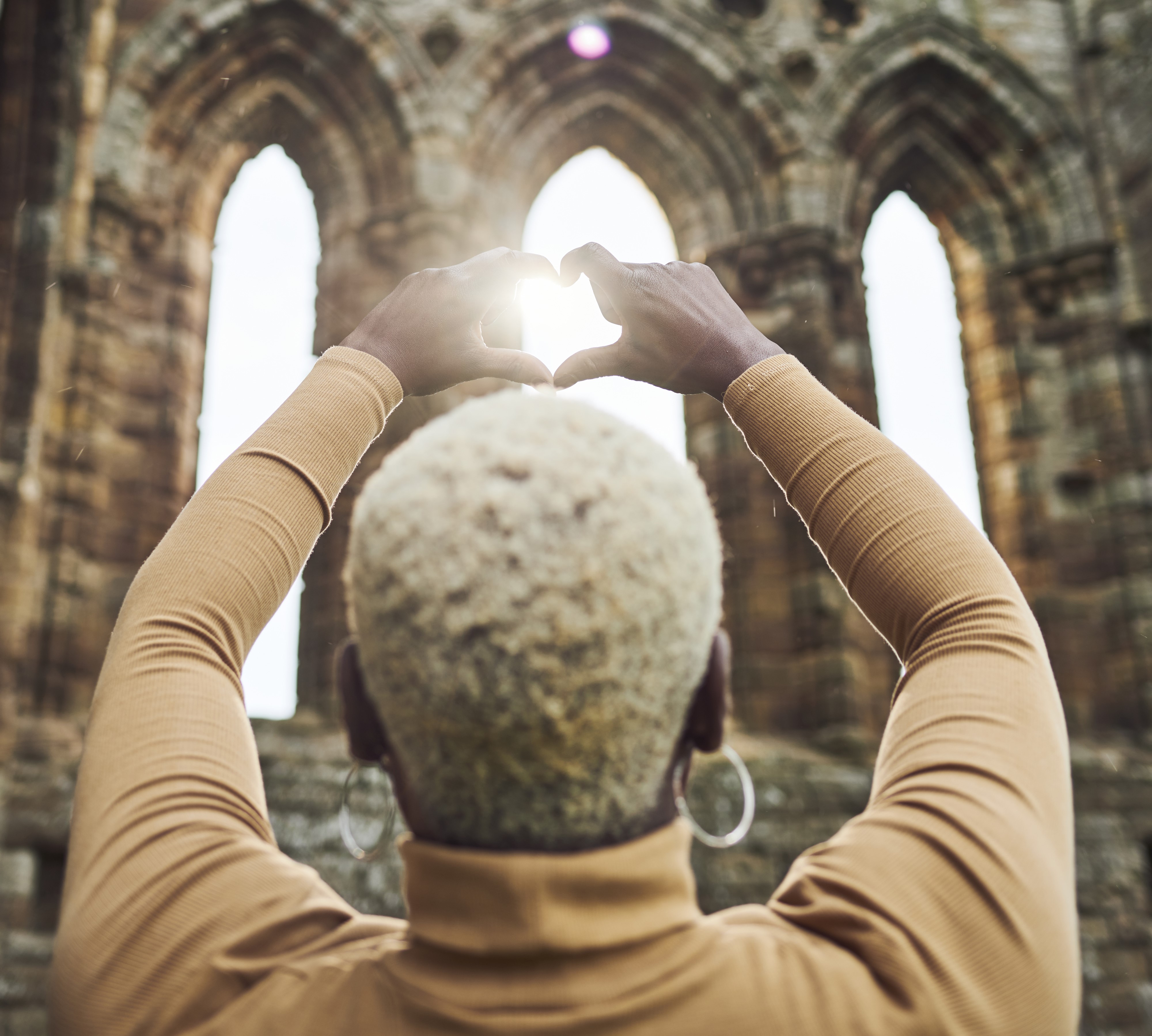 Image: A person looking at the sunshine streaming through the ruins of Whitby Abbey