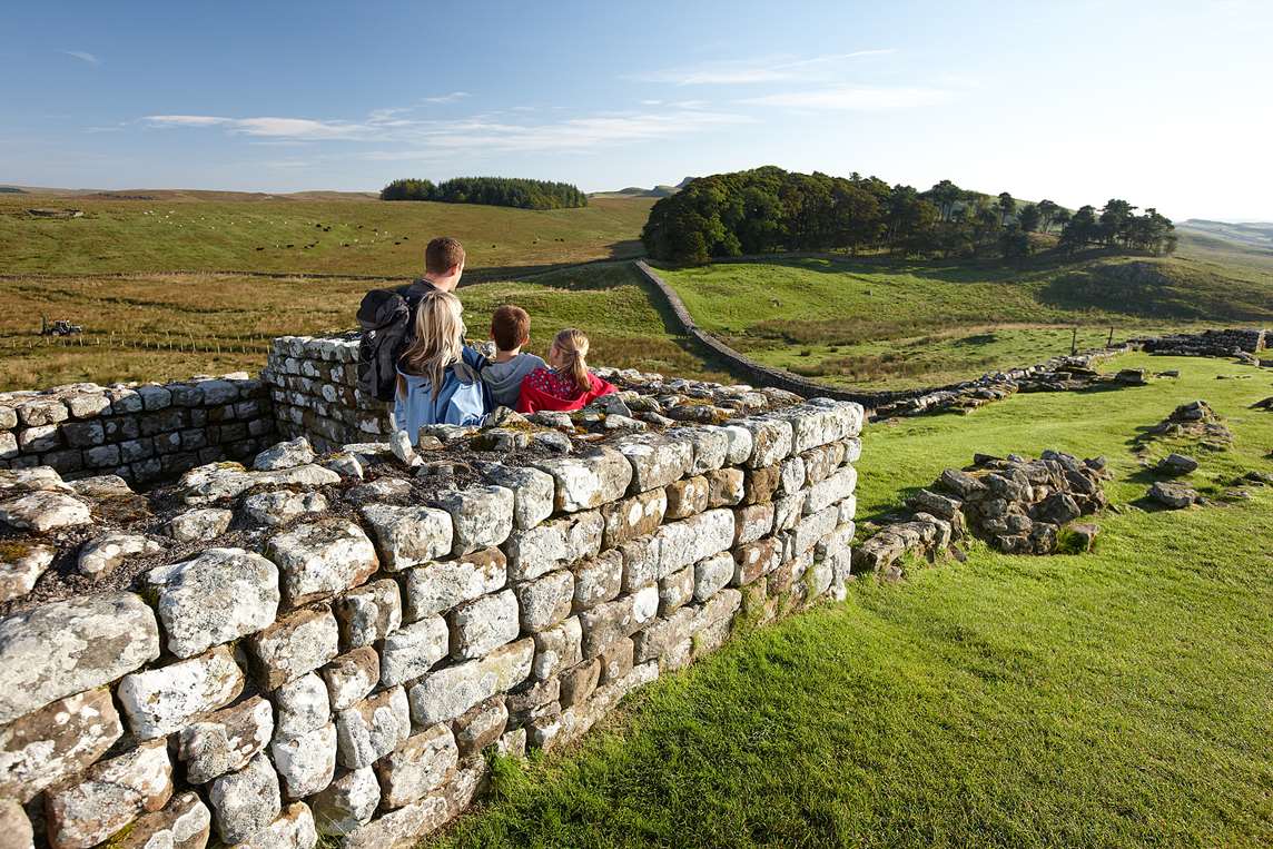 Image: visitors looking along Hadrian's Wall from Housesteads Roman Fort