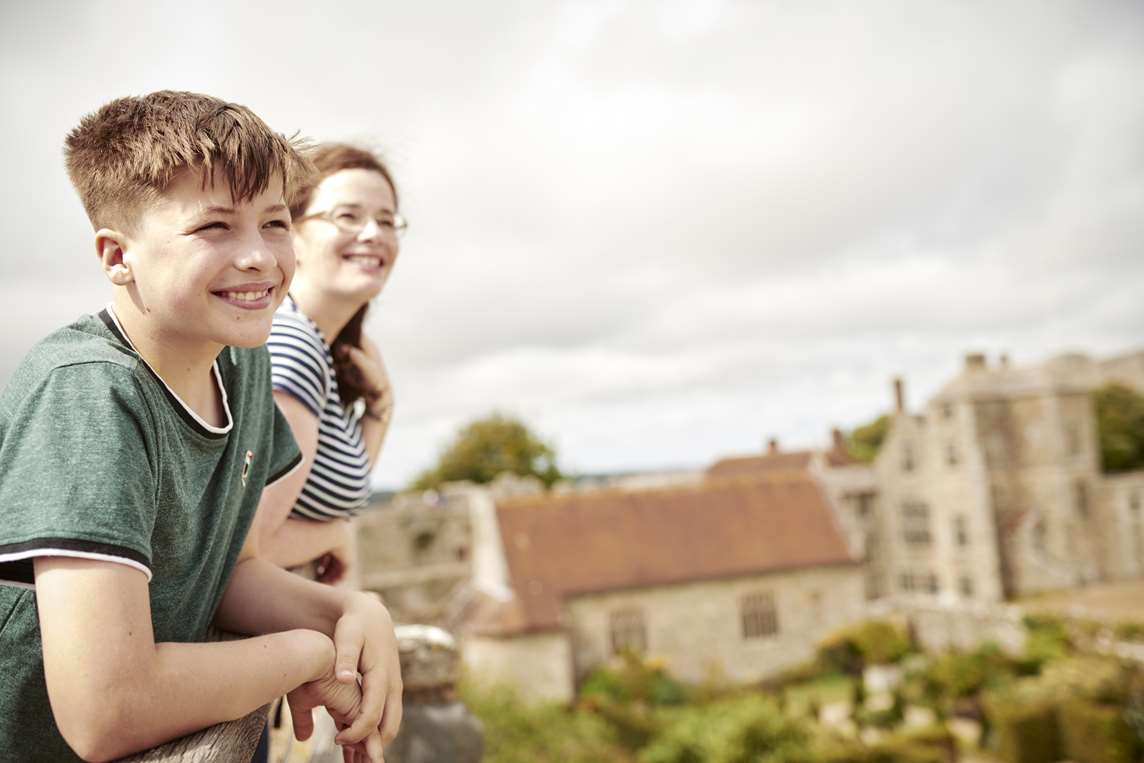 Image: A parent and child looking out from the battlements of Carisbrooke Castle