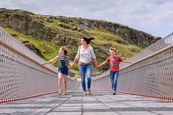 Family crossing Tintagel Castle Bridge