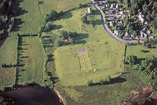 Aerial view of Ambleside Roman Fort, showing the central range of buildings and the edge of Lake Windermere in the bottom left corner
