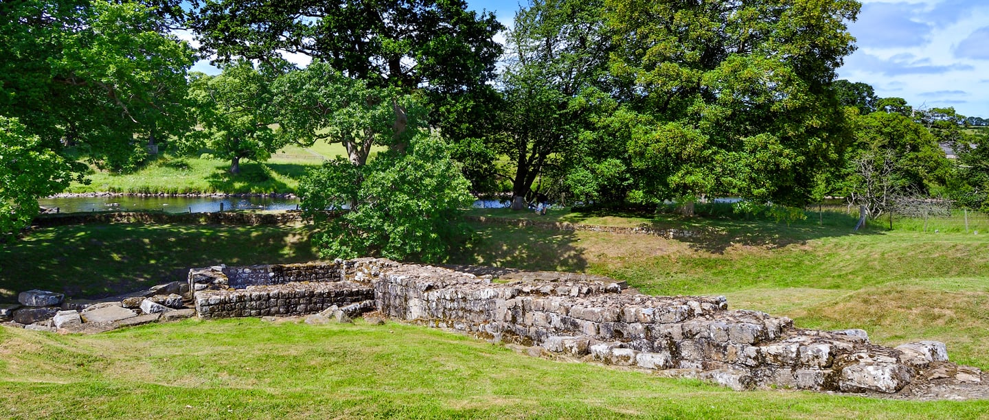 A view of Chesters Bridge Abutment on a sunny day, surrounded by trees.