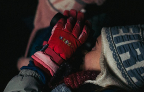 Two young people in winter clothing looking through binoculars at the night sky. Two young people in winter clothing looking through binoculars at the night sky.