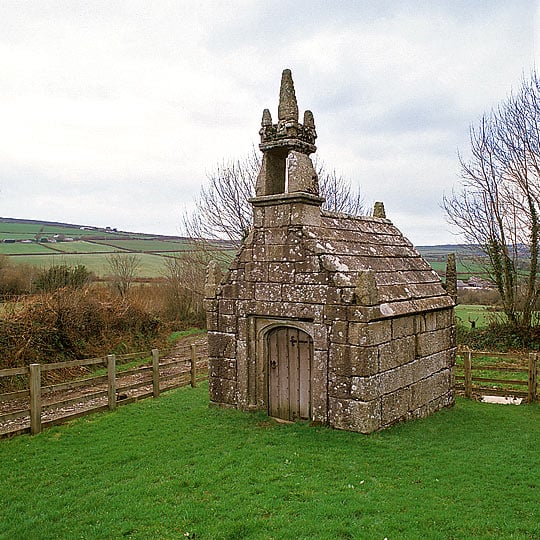 The front of the well-house with its bell turret and rolling fields beyond